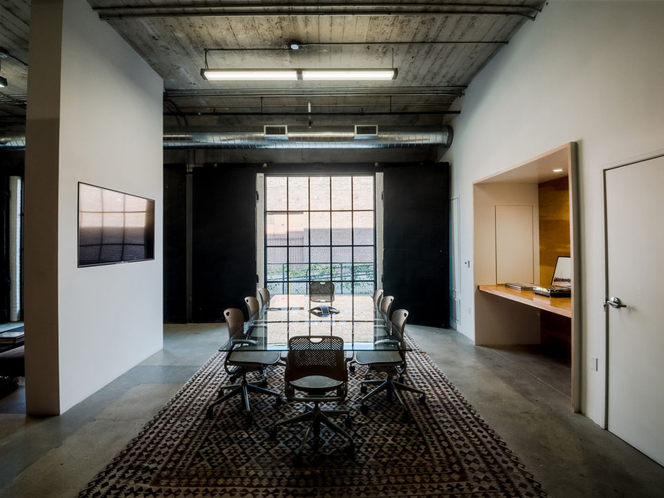 Conference room with black-white gabbeh carpet and expansive original window - 1924 paper company renovation - The Feel interior Design Los Angeles