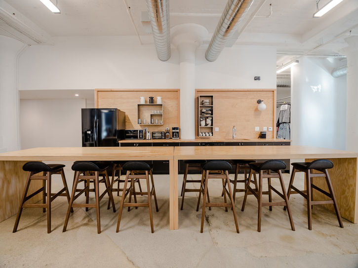 Communal kitchen island with stools in 1924 paper company renovation - The Feel interior design Los Angeles