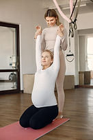 pregnant-woman-doing-yoga-with-personal-trainer-yoga-trainer-assisting-pregnant-woman-whil