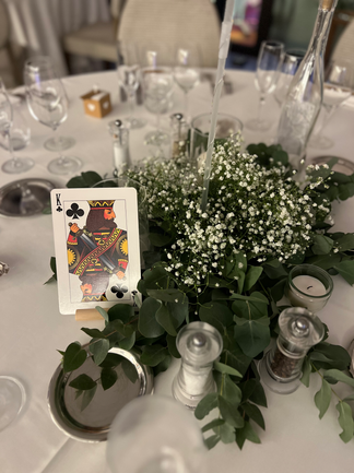 Centre de table avec gypsophile et jeu de carte comme marque table.