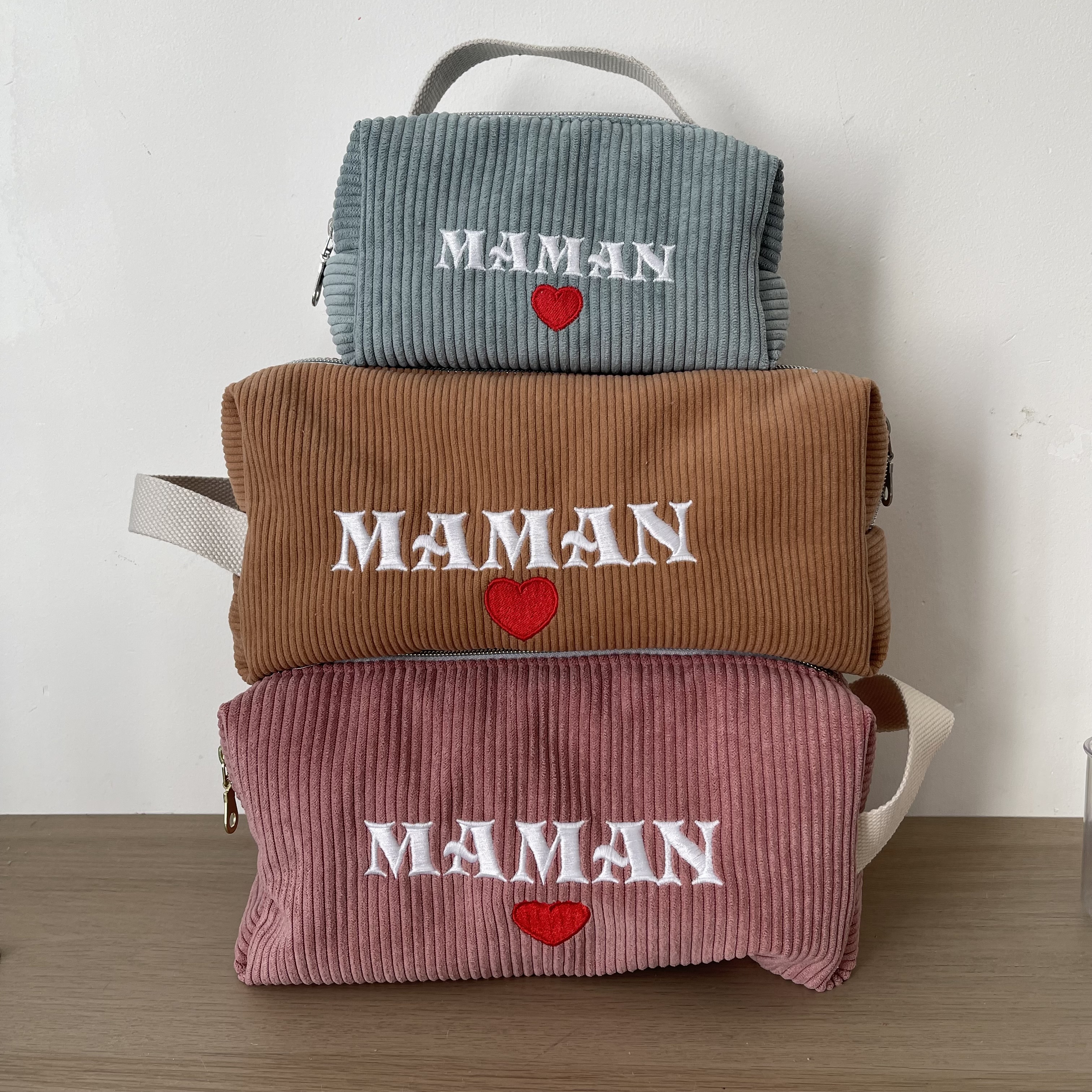Sac à cordons en velours côtelé avec broderie "MAMAN" et cœur rouge, disponibles en bleu, brun et rose.