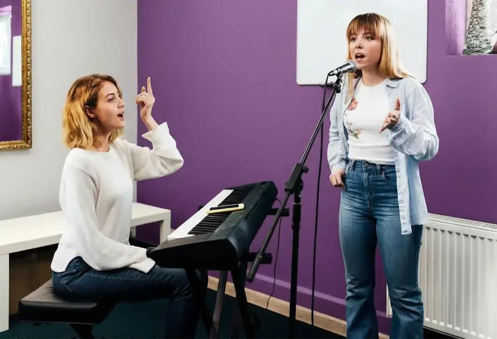 A teenage girl singing as guided by her vocal coach.