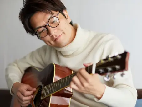 An adult practicing on an acoustic guitar.
