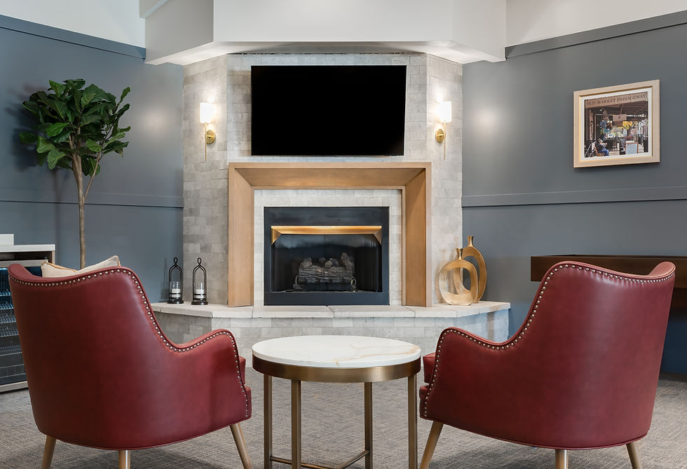 Cozy living room with fireplace, TV, red chairs, and a small round table.