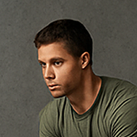 Man in olive green shirt, pensive expression