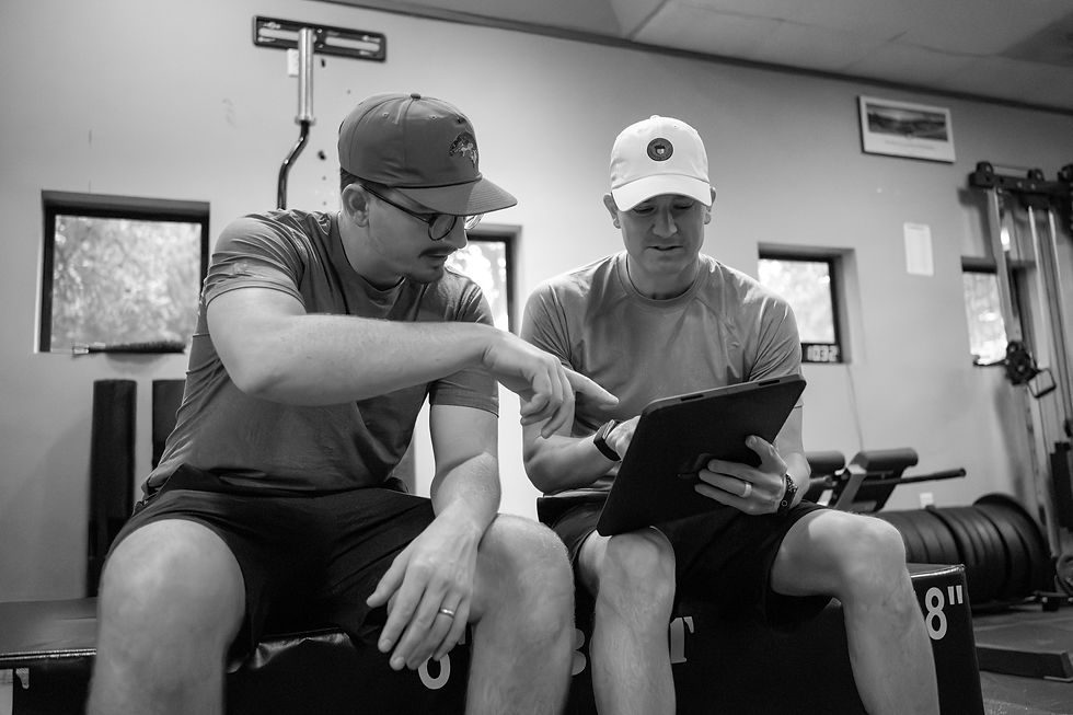 A golfer looking at information on an iPad with a coach after his golf performance assessment at Space City Golf Lab