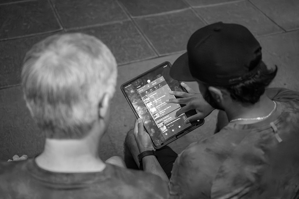 A Space City Golf Lab coach showing the workout plan to his elderly male client on an iPad