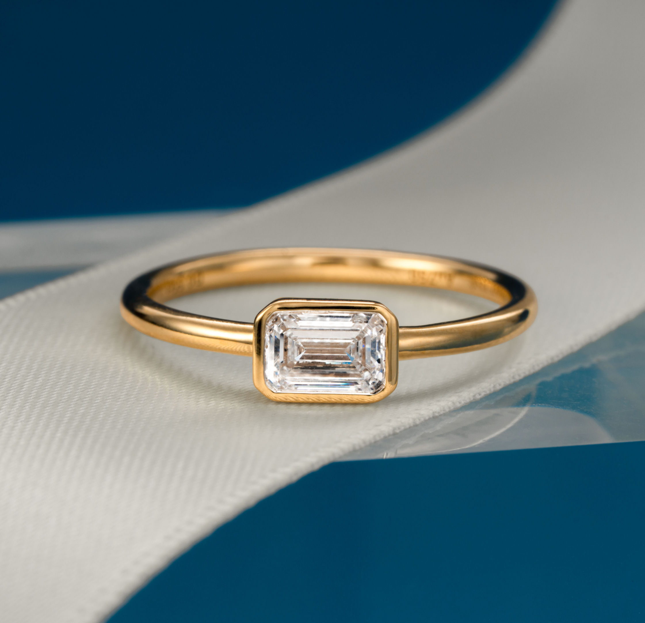 East-West Bezel Set Emerald Cut Natural/Lab Diamond Solitaire Ring | Yellow Gold