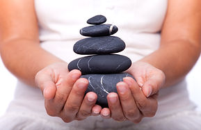 hands holding a stack of black stones (selective focus).jpg