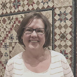 person standing in front of a quilt