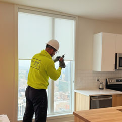 Nielsen Blinds, Shutters & Shades installer installing window shades inside a modern apartment unit