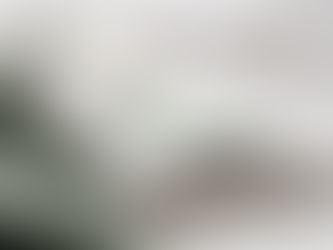 Mobile phone and a pair of reading glasses sitting on top of a pile of books.