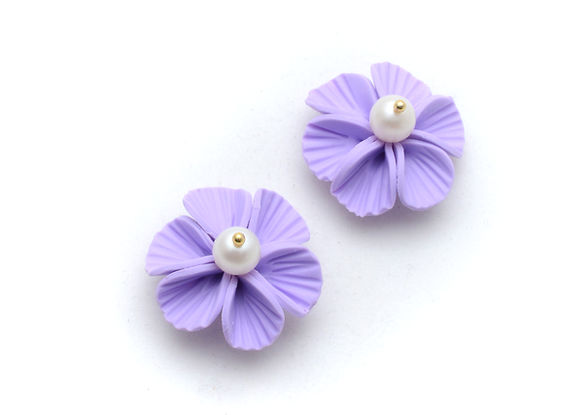 a pair of purple flowers with a pearl in the center