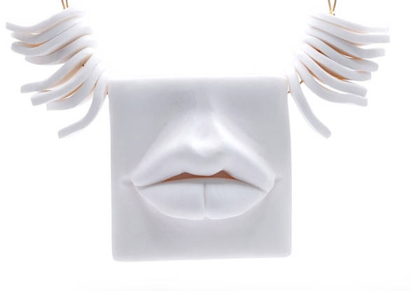 a necklace with a square with a face on it