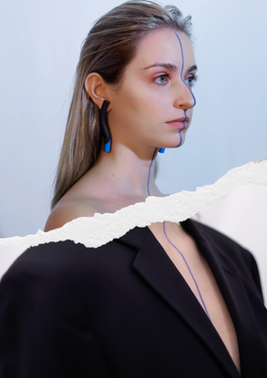 a woman with a blue line painted on her face wearing black and blue earrings