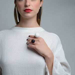 a woman wearing a black and white ring and earrings