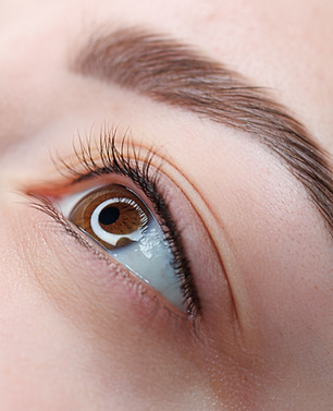 A close-up of the girl's eyes with permanent makeup between the eyelashes is the finished 