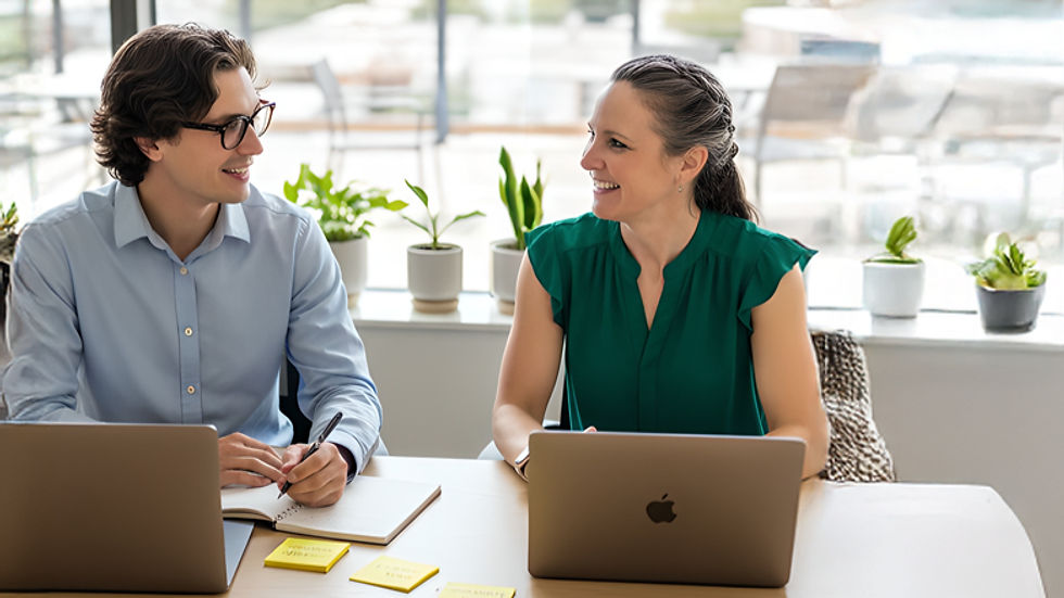 Two people collaborating at a desk, representing guided support and clarity through conversation.