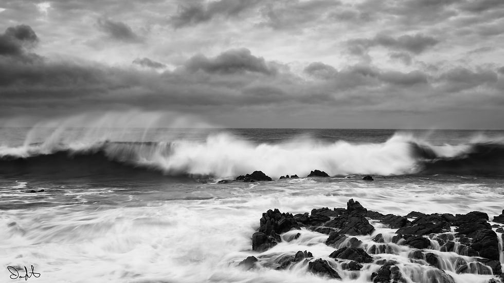 A wave crashing with wind blowing