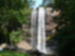 Wide angle view of Toccoa Falls surrounded by lush greenery