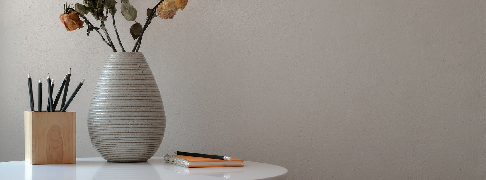 flower-vase-beside-notebook-and-pencils-