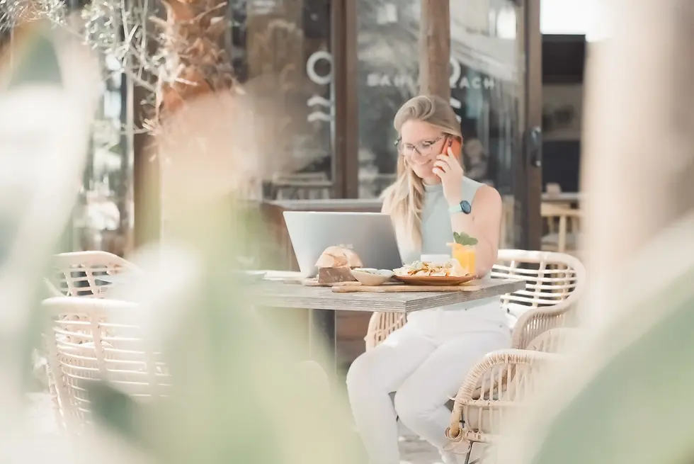 Jolien bellend met laptop op terras