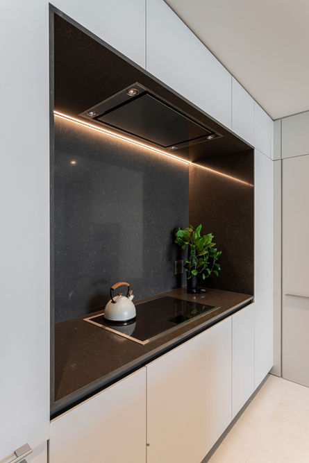 Modern kitchen with sleek black glass backsplash, integrated appliances