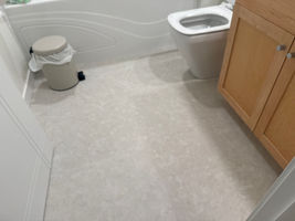 A light grey vinyl floor with a subtle stone-like texture, giving a clean and practical look.