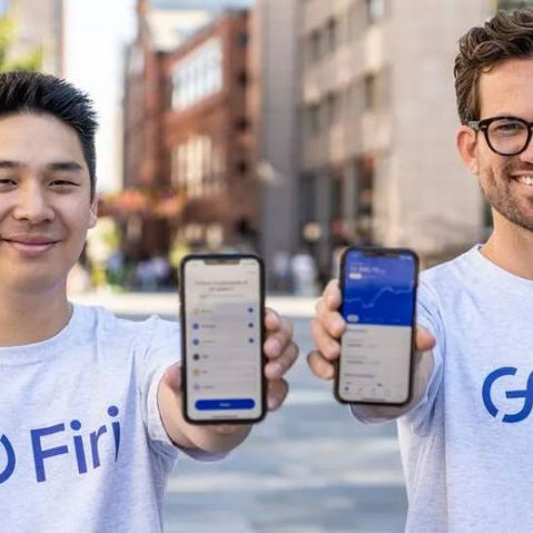  To personer iført Firi-skjorter viser smarttelefoner med kryptoapplikasjoner, relatert til Firi bonusprogram. 