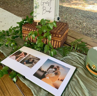 Table at a wedding with the couple's guest book surrounded by green details