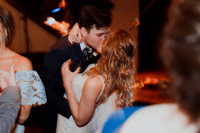 Bride and Groom kissing with a band playing in the background