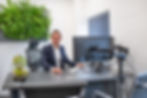 Andrew Robbins, Managing Director at Blackmore print, sat at his desk surrounded by greenery!