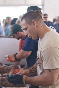 Primitive man works vigorously to open the oyster.