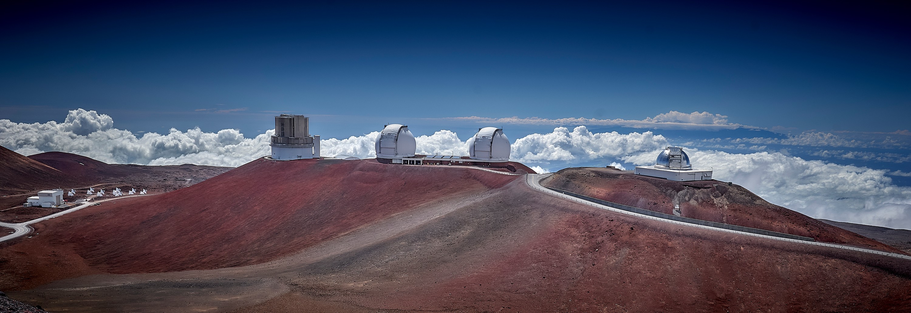 Four major telescopes atop Mauna Kea from left: Submillimeter Array, Subaru, Keck, and NASA Infrared. Haleakela volcano on Maui hides in the distant clouds