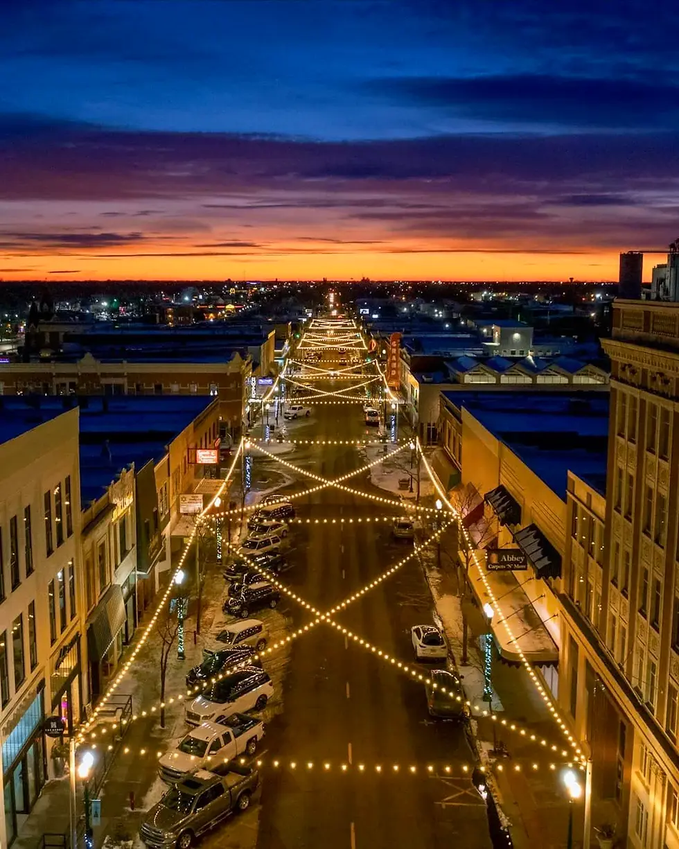 Railside Plaza and downtown Grand Island illuminated with string lights at sunset