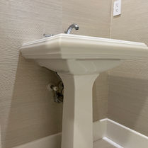 Beige Grasscloth wallpaper is installed in the Powder room.