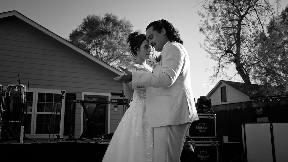 Bride and groom sharing their first dance with heads gently touching during an intimate backyard wedding reception in Houston.