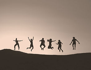 six silhouette of people jumping on a hill