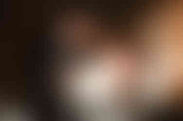 bride and groom cutting cake under fully candle lit reception space