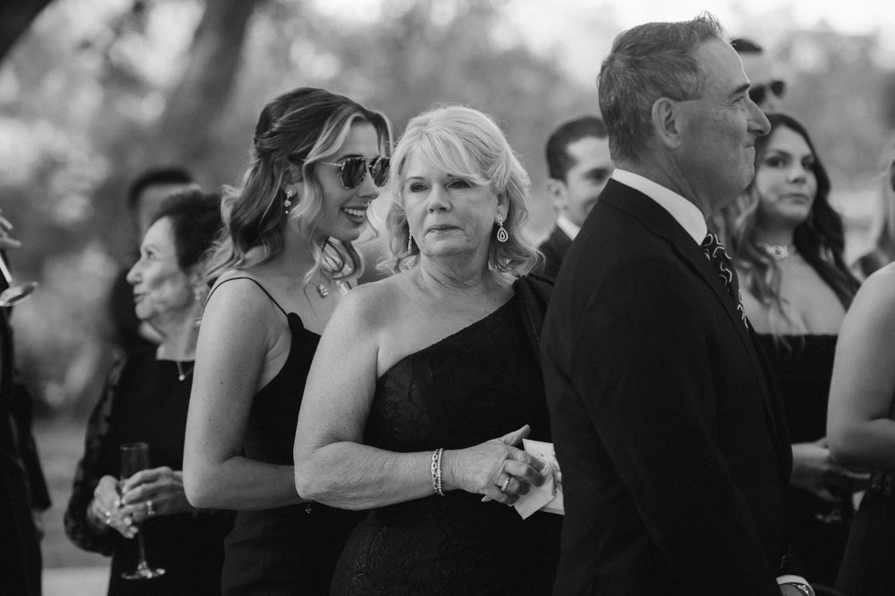 mother of groom looking over at son crying as he sees his bride