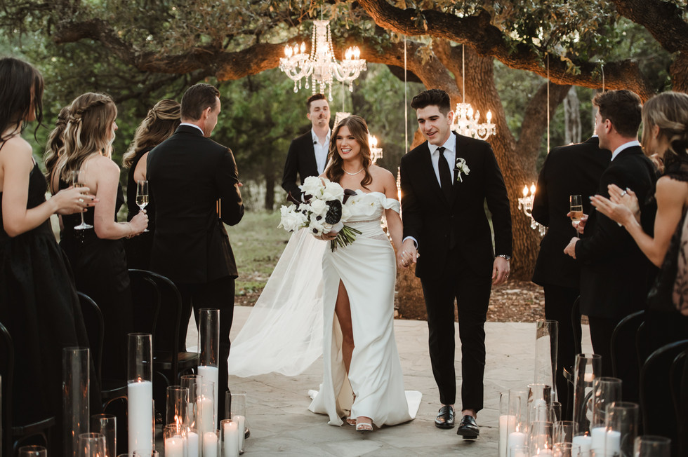 Elegant black-and-white wedding ceremony at The Addison Grove with chandeliers hanging from a sprawling oak