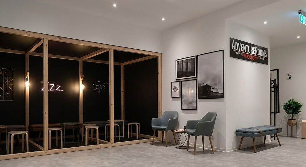 Moderner Wartebereich der AdventureRooms Hamburg – helles, minimalistisches Design mit Holzrahmen-Elementen, grauen Sesseln und Schild an der Wand