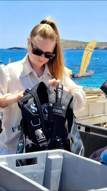 Packing dive gear into equipment boxes before a boat dive on Gozo