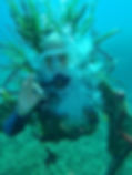 A diver under water with a Neptune's costume: long green hair and a bushy white beard.