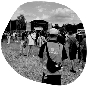 Ein Mensch in Awareness Uniform steht vor einer Bühne