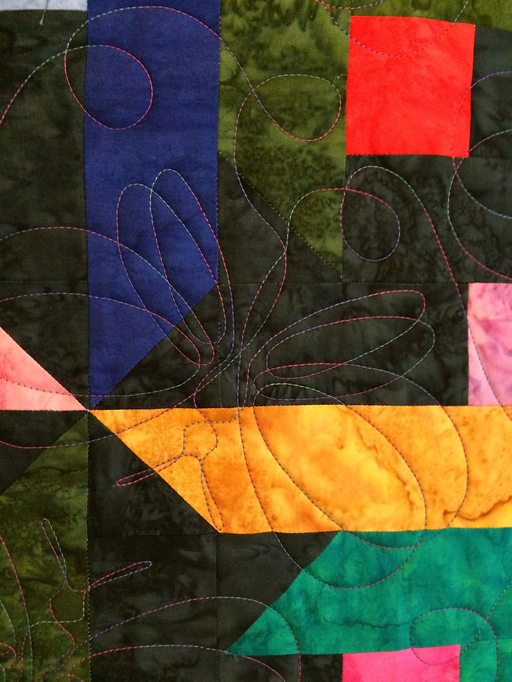 close up of butterfly quilting design on jewel tone batik quilt