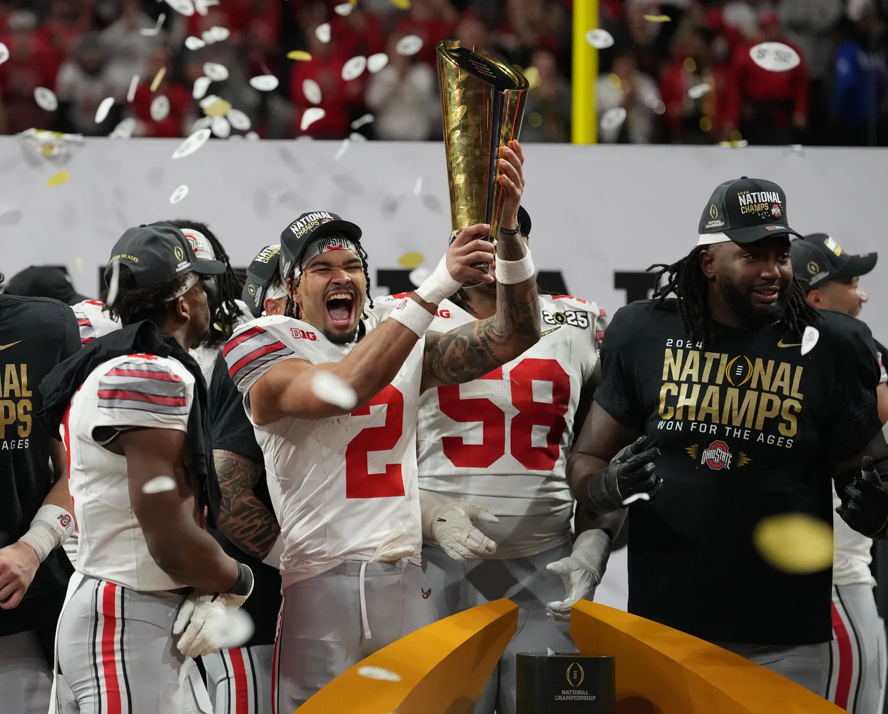Emeka Egbuka holding Ohio State Football's 2024 National Championship Trophy.