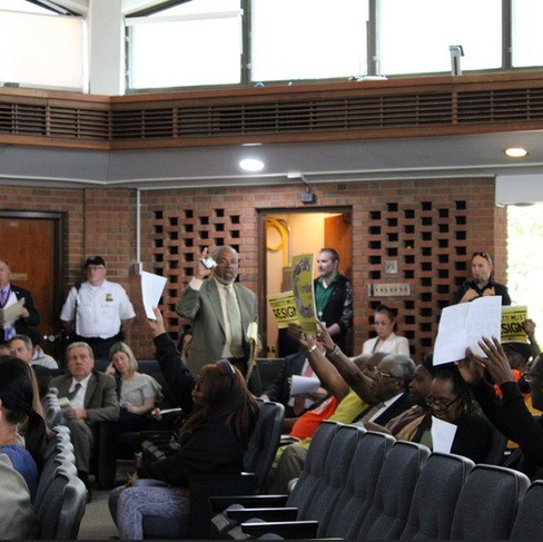 (Left) Frederick Brewington announcing his departure with audience members holding signs. (Right) A segment of the crowd following Brewington. Sept. 16, 2025