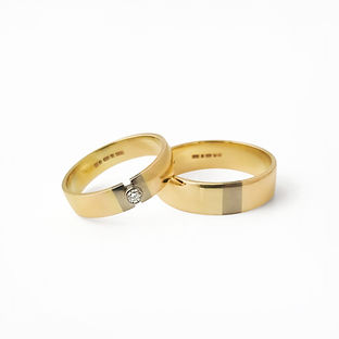 Two yellow gold wedding bands, both with a white gold section, one also with a small diamond by Heather O'Connor