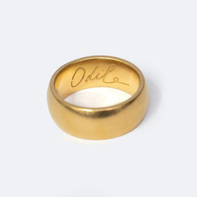 Chunky 22ct yellow gold wedding ring with the handwritten name Odile engraved inside, on white background, Heather O'Connor